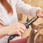 Locken eindrehen beim Friseur mittels Lockenstab