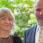 Ilona Böttcher (eine blonde Frau in mittlerem Alter im schwarzen Dress mit Goldkette) und Mike Kämmer (ein Mann im mittleren Alter mit grauem Bart im schwarzen Anzug und heller Krawatte) zum Jubiläum der Figaro GmbH